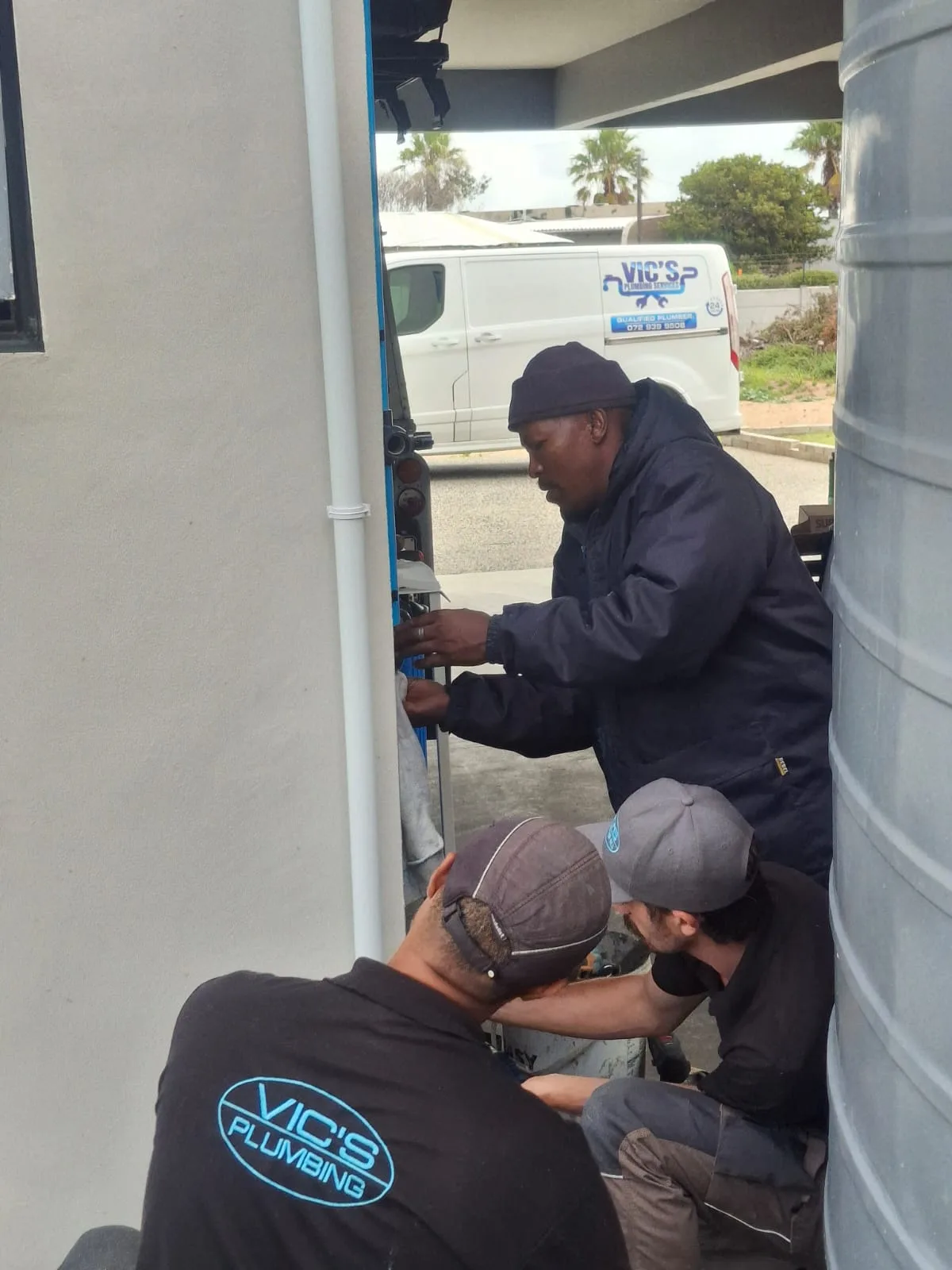 The Vic's Plumbing crew on site next to a branded service van