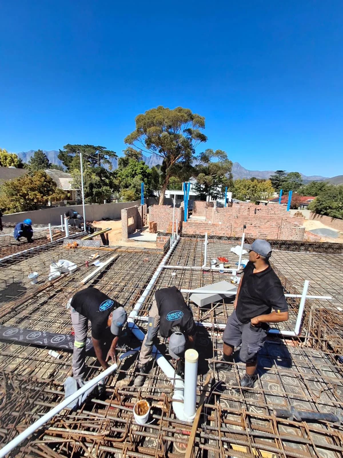 Vic's Plumbing team installing pipework on site in the Helderberg